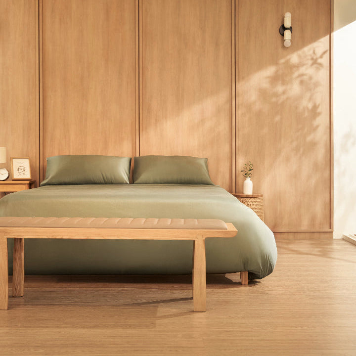 Bedroom with wooden bed frame, green bedding egyptian cotton. Cream interior design